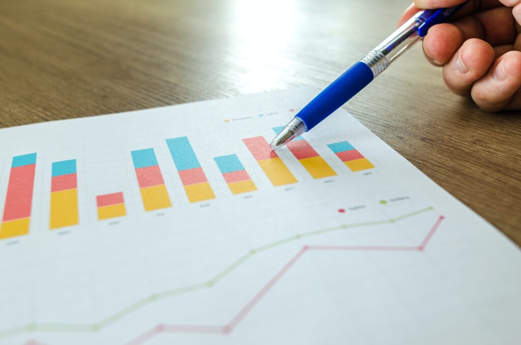 Hand holding pen pointing at graph