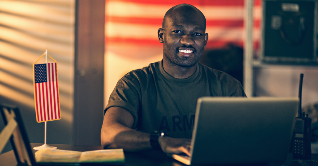 Soldier in Army shirt works at laptop computer