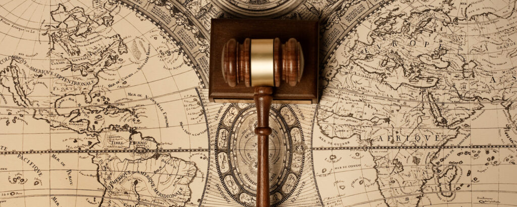 Gavel in foreground, world map in background.